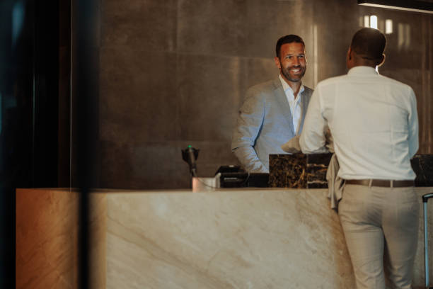istock Caucasian hotel receptionist and African-American client smiling after successfully solving problem 1500653682