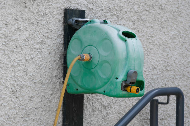 istock Yellow rubber hose and wall mounted holder outdoors 1500654236