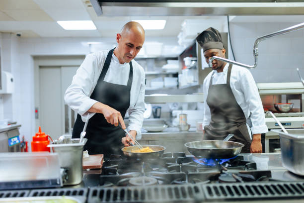 istock Caucasian chef teaching younger African-American coworker 1500656393