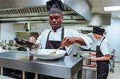 African-American chef finishing dish