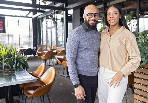 Smiling black couple standing in a restaurant patio