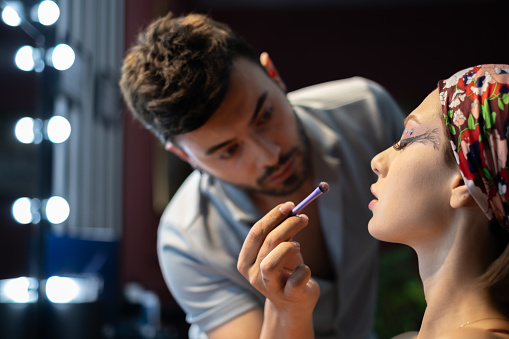 Makeup artist working on a young beautiful model.