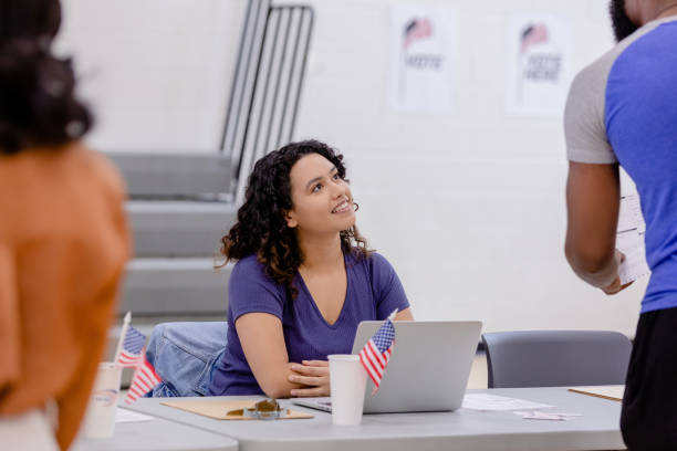 istock Female polling volunteer assists unrecognizable young man 1500680757