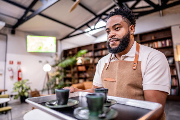 istock Waiter carrying a serving tray with coffee in a cafe 1500680929