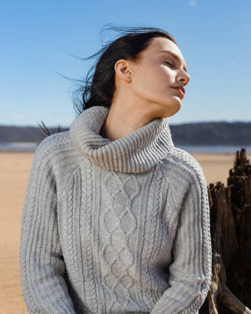 istock young brunette woman sitting on a sandy beach and getting rest warm autumn weekend 1500681075