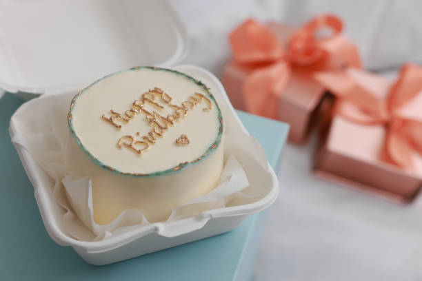 Delicious decorated Birthday cake on light blue surface, closeup. Space for text