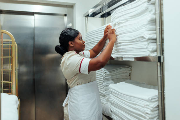 istock African-American maid counting clean bed sheets in hotel laundry 1500682356