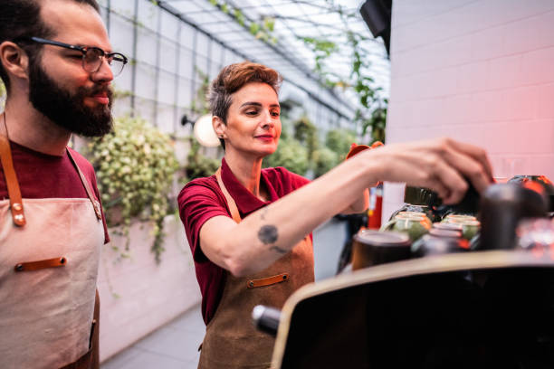 istock Barista teaching a coworker how to make coffee in a cafe 1500682965