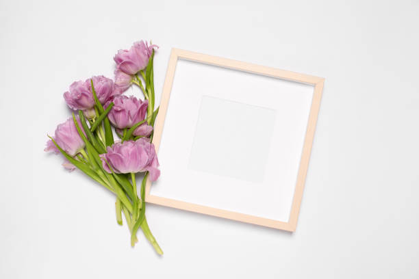 istock Empty photo frame and beautiful tulip flowers on white background, flat lay. Mockup for design 1500684292