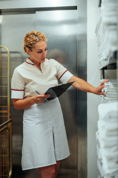 istock Blonde maid checking clean sheets in hotel laundry 1500684704