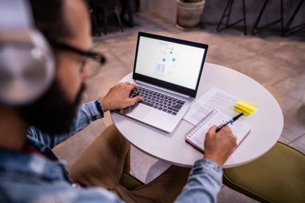 istock Man using the laptop in a coffee shop 1500684762