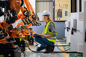 Female engineer worker working with robotic machine automation