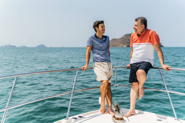 istock Father and son talking on boat deck during a yacht trip 1500687746