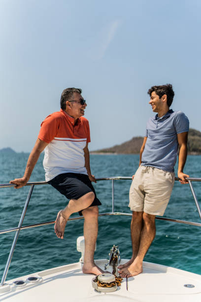 istock Father and son talking on boat deck during a yacht trip 1500687803