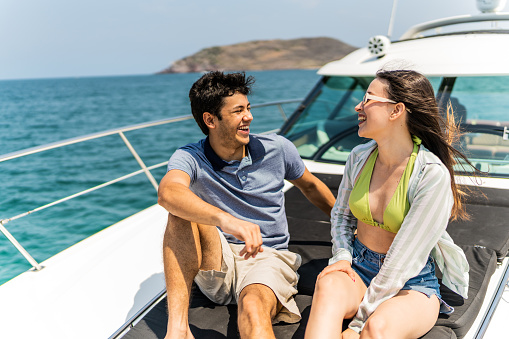 Young couple or siblings talking during a yacht trip