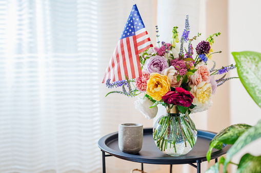 Close up of bouquet of flowers in vase with Usa flag. Independence day of America. Decorated home for July 4th. Memorial day. Space