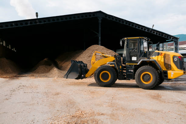 istock Wheeled loader moving sawdust in wood processing factory 1500696818