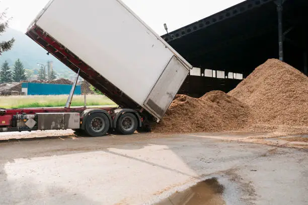 Photo of Truck unloading wood waste at factory warehouse