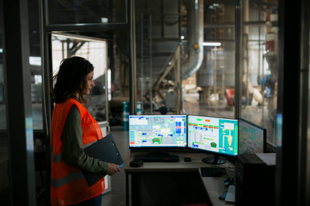 Female supervisor controlling automatic production system in wood factory stock photo