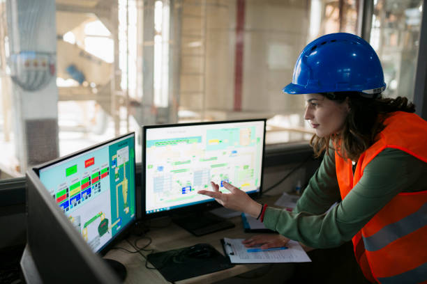 컴퓨터 모니터에서 자동화된 목재 가공 공장을 모니터링하는 여성 기술자 - computer control room hardhat computer monitor 뉴스 사진 이미지