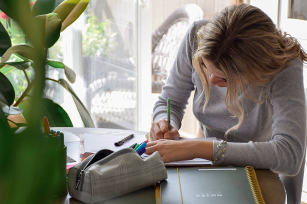 istock Young teenage girl student writing notes while doing homework 1500700371