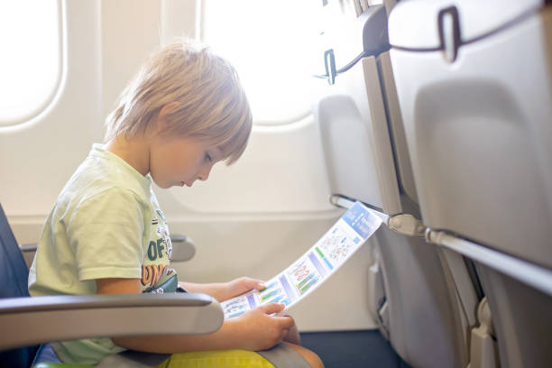 かわいい就学前の子供、遠くの飛行機で飛んで、飛行機の中でハンバーガーを食べる - concepts airport ideas watching ストックフォトと画像