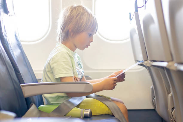 かわいい就学前の子供、遠くの飛行機で飛んで、飛行機の中でハンバーガーを食べる - concepts airport ideas watching ストックフォトと画像