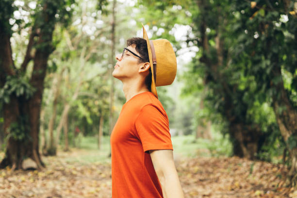 Young man breathing deep fresh air outdoor.