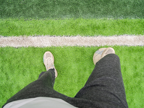 Soccer player stepping on the ball and standing on the football field