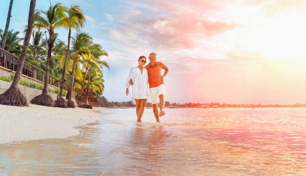 Couple in love hugging while walking on a sandy exotic beach. They have an evening walk by Trou-aux-Biches seashore on Mauritius island. People relationship and tropic honeymoon vacations concept pareja enamorada abrazándose mientras camina por una playa exótica de arena. tienen un paseo nocturno por la orilla del mar de trou-aux-biches en la isla de mauricio. relación con las personas y concepto de vacaciones de luna de miel tropicales