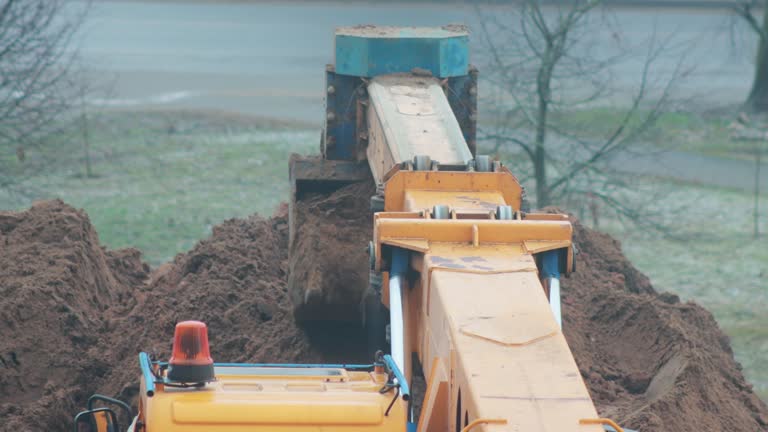 auto excavator with rotary bucket and telescopic boom digs a hole to replace the pipeline, industry