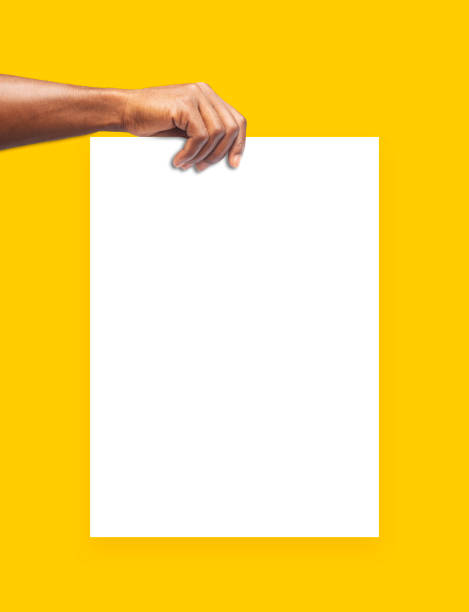 istock hand holding blank paper isolated on yellow background. design mockup, front view, clipping path, Free copy space, mask 1500731361