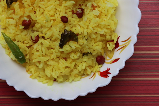 Poha or Kanda Poha popular Maharashtrian breakfast recipe made from red or white flattened rice, potatoes, onions, herbs and spices, south Indian food