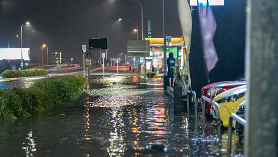 Auckland, New Zealand - January 27, 2023: Flooding after a record breaking heavy rain caused chaos in many suburbs in Auckland. The image was taken near the intersection in Greenlane, showing the main road  and parked cars on sale with the flooded water just 50 meters away from the off-ramp of the Southern Motorway 1.