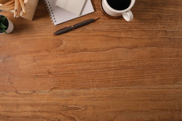 istock Flat lay notepad, cup of coffee, pen and pencil holder on wooden table. Top view with copy space. 1500744521