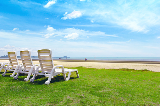 White beach chair on tropical beach with blue sky