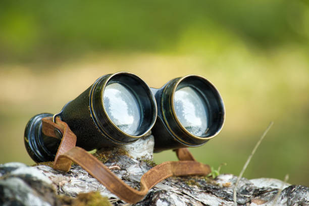 Old metal binoculars on a white table. Old military accessories for infantry. White background.