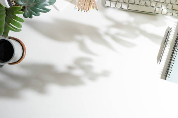 istock White office desk with keyboard, coffee cup, notepad and potted plant. Copy space for your text. 1500756156
