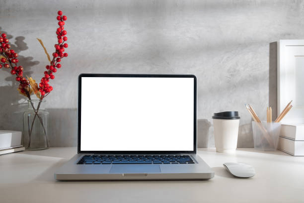 istock Laptop computer with blank screen, paper cup, books and stationery on white table. 1500758803