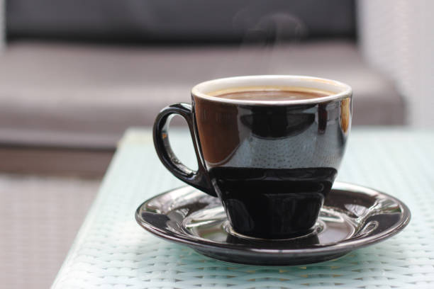 istock a cup of hot coffee on a glass table. blurred background. copy space. 1500760232