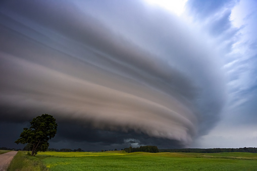 Angry supercell storm influenced by Climate change. Dangerous storm supercell shelf cloud with layers. High quality photo