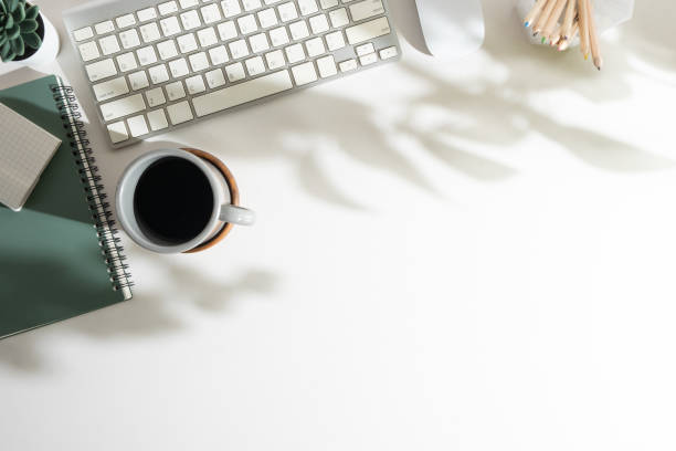 istock White office desk with notebook, keyboard, pencil holder and cup of coffee. Top view with copy space for your text. 1500762498