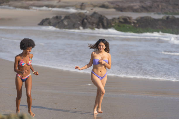 istock Friends in bikinis, playing on the seashore 1500763733