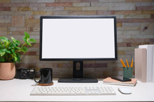 istock Blank computer monitor, coffee cup, books, camera and potted plant on white table. 1500763804