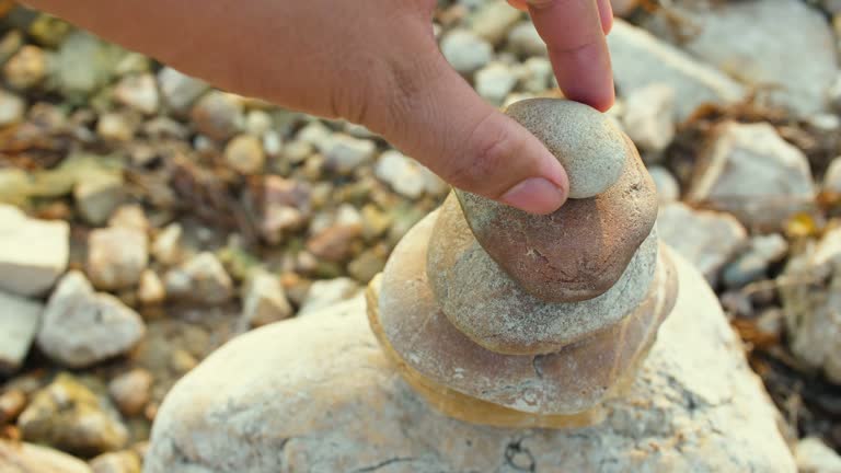 Man Building The Pile Of Stones At The Beach