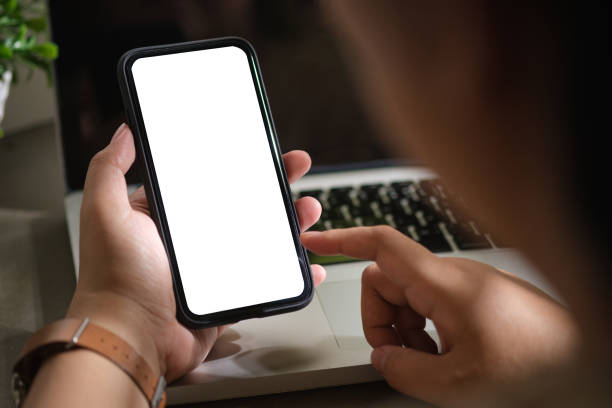 istock Woman using mobile phone at her working desk. Close up view, Blank screen for your advertise design. 1500764143
