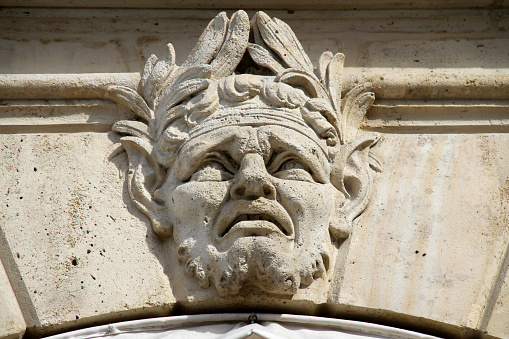 A carved face on a wall in the heart of Paris