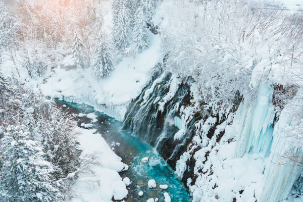 Shirahige Waterfall with Snow in winter, Biei river flow into Blue Pond. landmark and popular for attractions in Hokkaido, Japan. Travel and Vacation concept