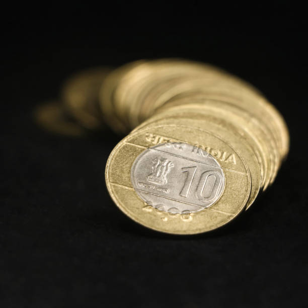 indian ten (10) rupee coins arranged in a curved row
