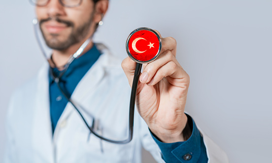 Doctor holding stethoscope with Turkey flag. Turkey Health and Care Concept, Turkish flag on stethoscope.